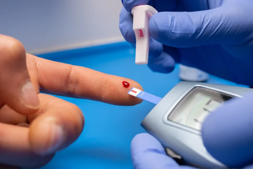 Profissional da saúde fazendo teste de diabete no paciente.